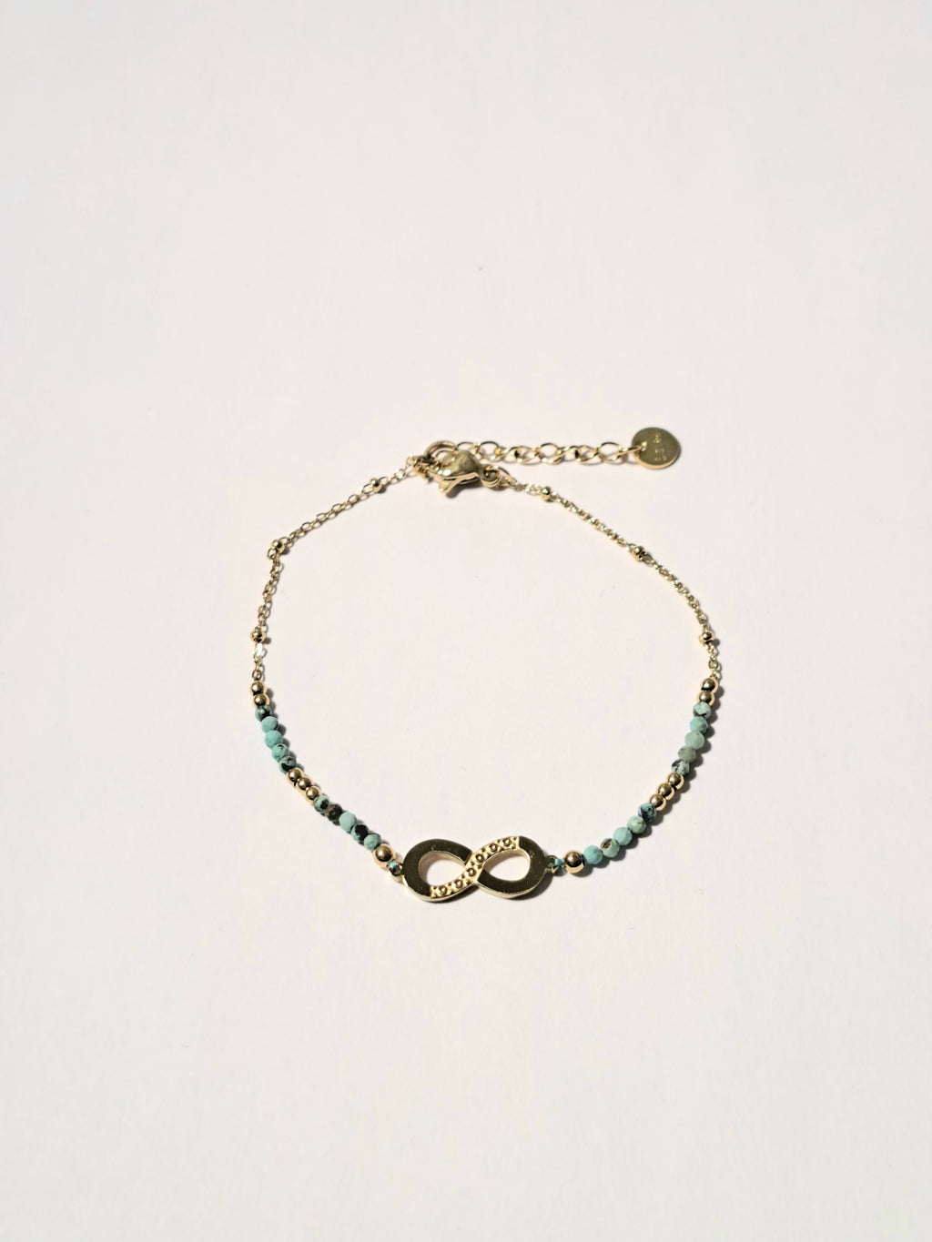 Bracelet doré – Symbole infini & perles vert émeraude