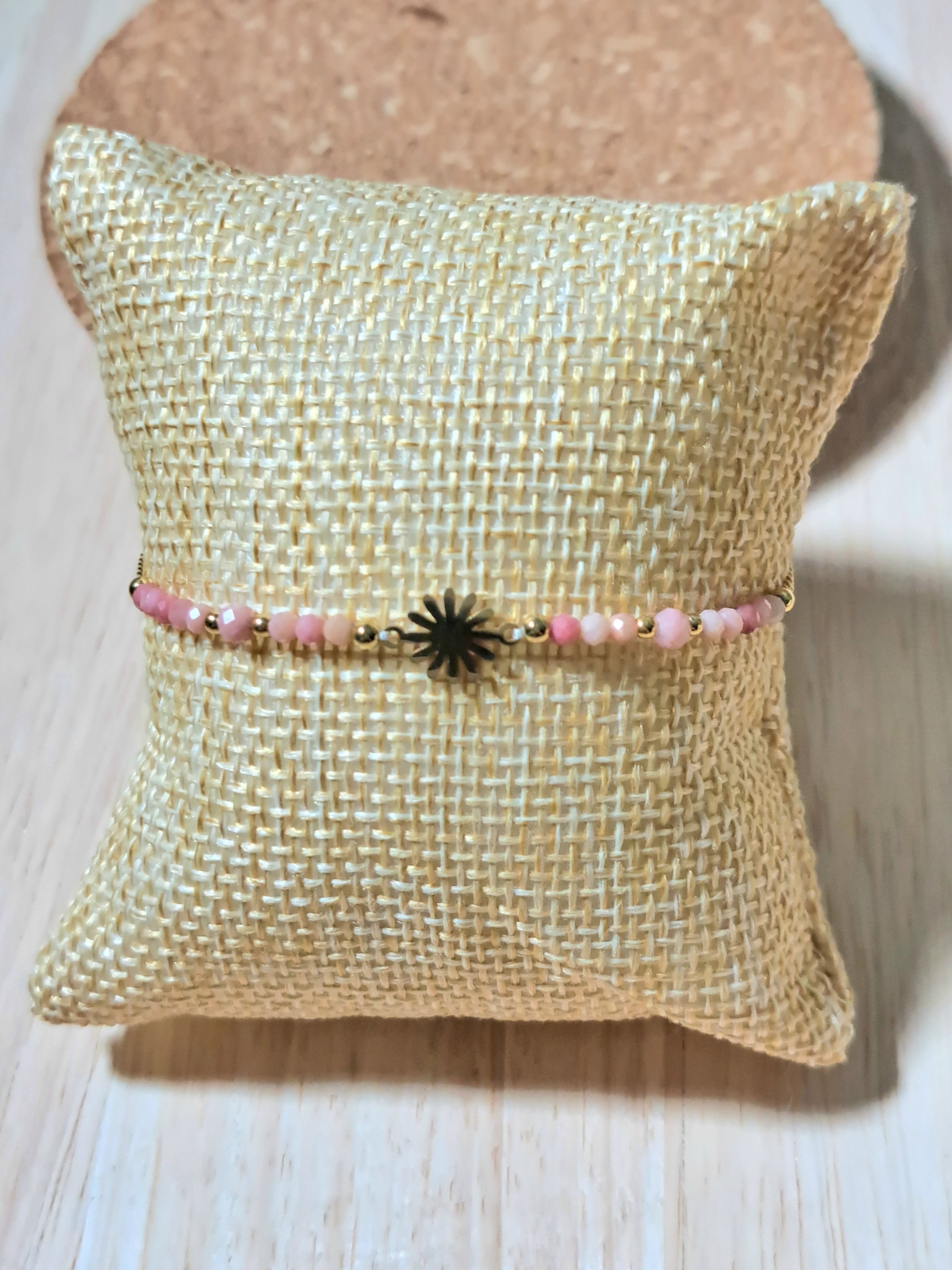 Bracelet délicat orné d’un charm soleil doré & de perles roses.